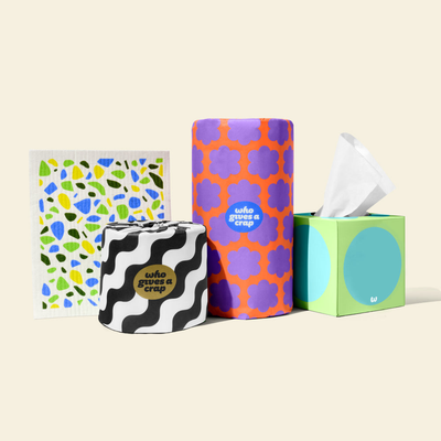 A bundle of Who Gives A Crap products made up of a eco-friendly toilet paper roll, a kitchen towel roll, a box of tissues and a Dream Cloth.